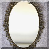 DM07. Oval mirror with metal surround and 2 glass ”gems.” 25” x 17” 